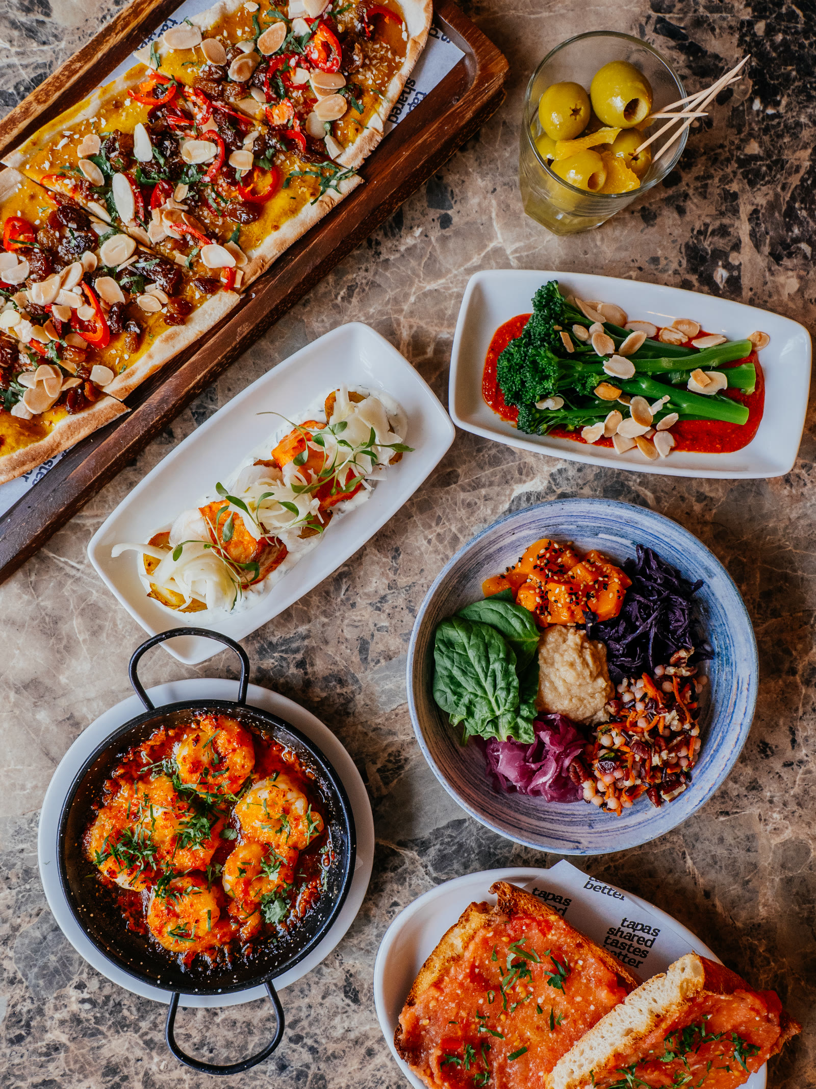 A spread of Baresca tapas dishes on a marble table